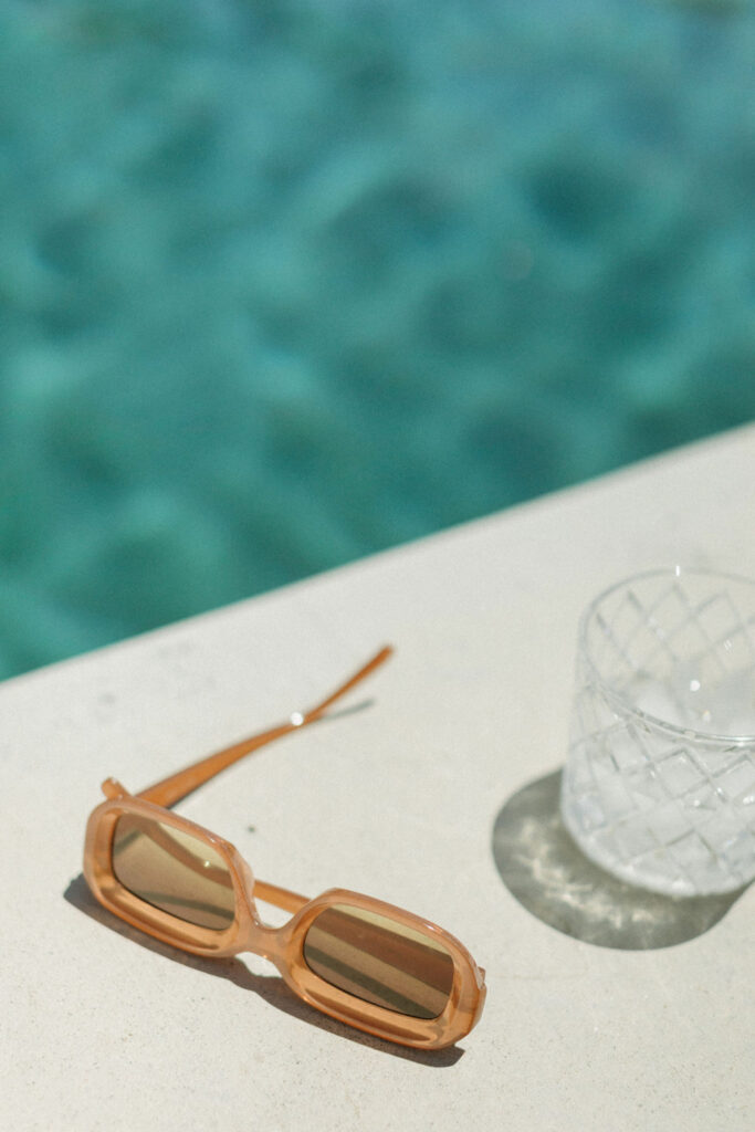 Editorial wedding photography of sunglasses near a pool