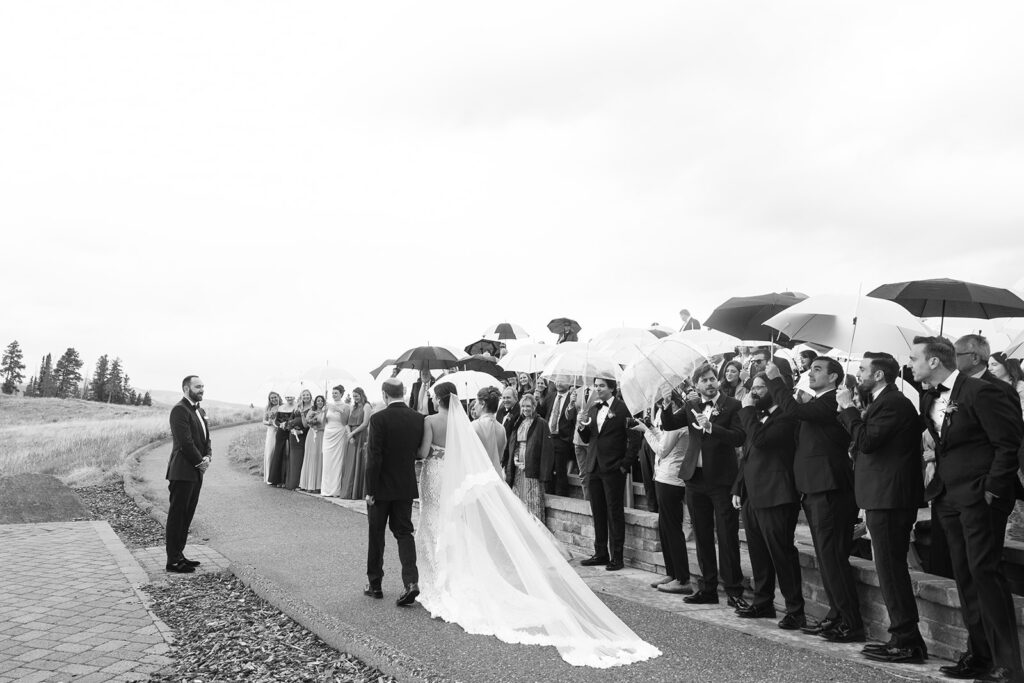 Guests stand with clear umbrellas for a Vail Mountain wedding ceremony